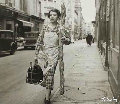 1945年，巴黎，拿着法棍和葡萄酒的法国妇女